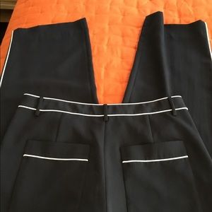 Tibi black trousers with white piping.